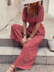 Red floral wide-leg jumpsuit with smocked bodice and puff sleeves.
