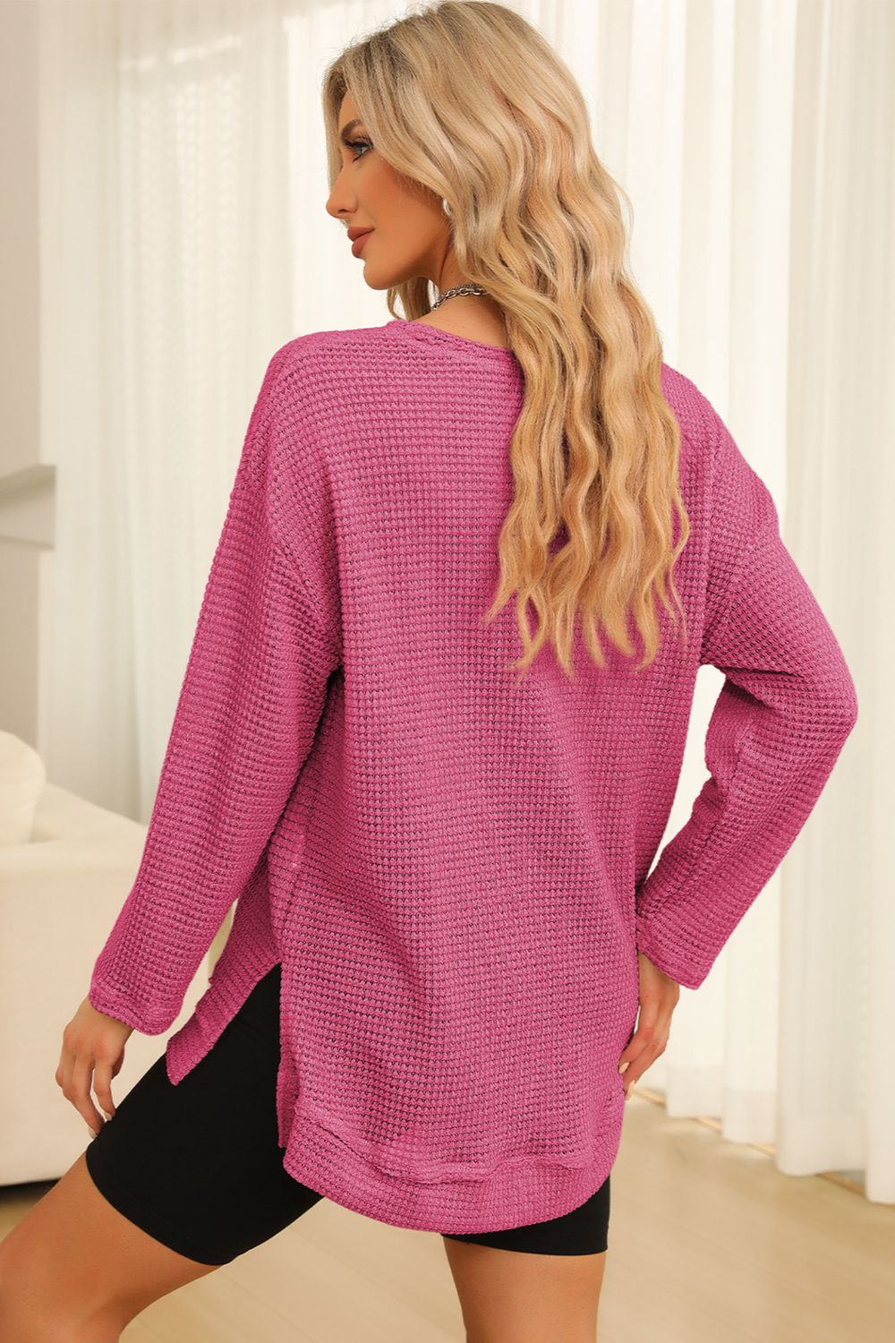 Waffle knit oversized top in pink with long sleeves and slit hem detail.