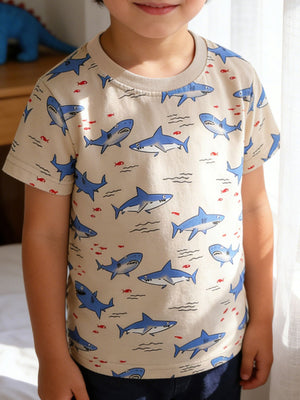 Toddler crew neck t-shirt with allover blue shark and red fish print on a tan background.