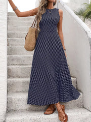Dark blue polka dot maxi dress with a flattering silhouette, sleeveless, round neck, and flared skirt.