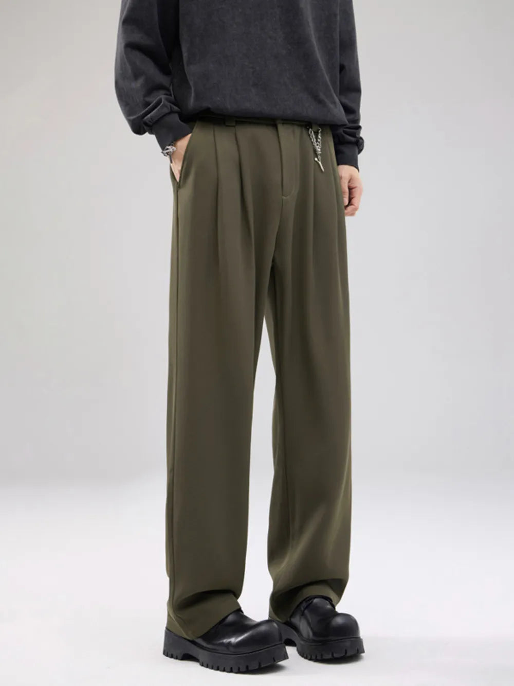 Men's army green drawstring wide-leg sweatpants with pleats and a chain detail.