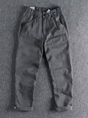 Men's grey elastic waist cargo pants with button closure and cuffed hems.