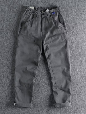 Men's grey elastic waist cargo pants with button closure and cuffed hems.