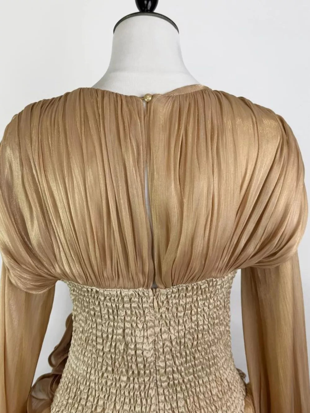 Gold ruffled mini dress with ruched corset waist and long sleeves.