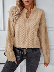 Camel cable knit sweater with keyhole neck and long sleeves.