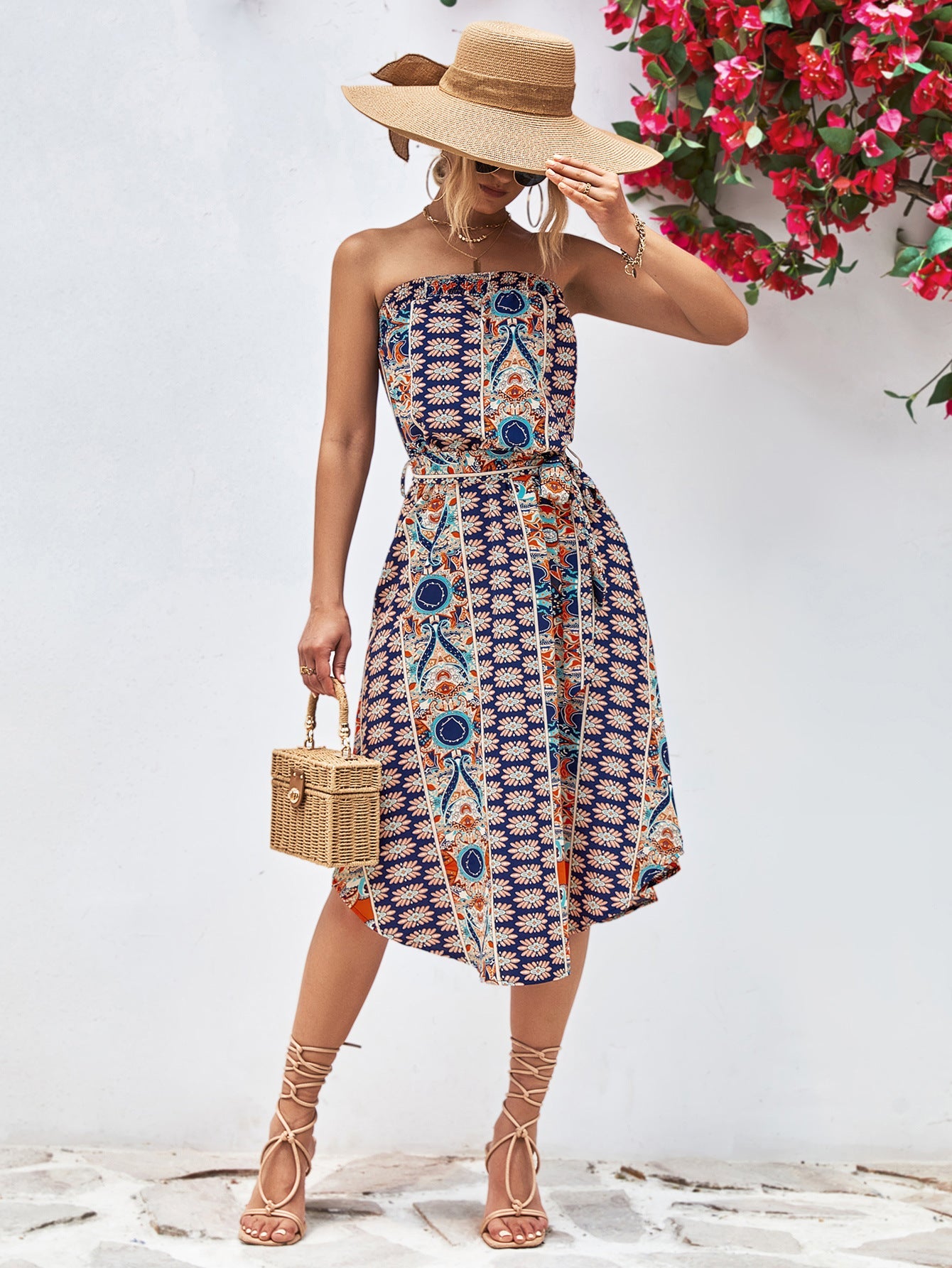 Printed bandeau midi dress with asymmetric hem and belt in dark blue with multicolor pattern.
