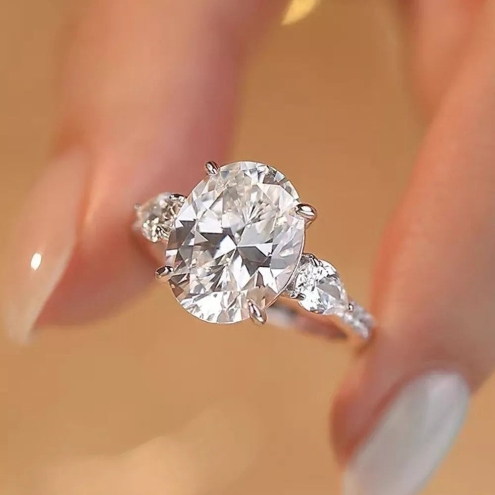 Dazzling Moissanite oval ring in sterling silver with side pear stones.