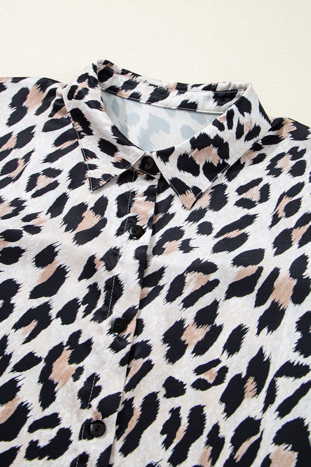 Leopard print oversized button-down blouse with black buttons and a collared neckline.