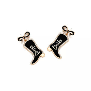Black cowboy boot dangle earrings with "Bride" text and crystal trim, attached to a bow stud.