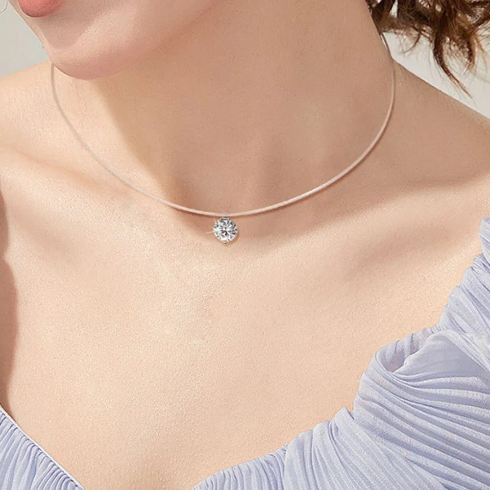 Silver floating moissanite necklace with a single clear round-cut stone on a thin clear cord.