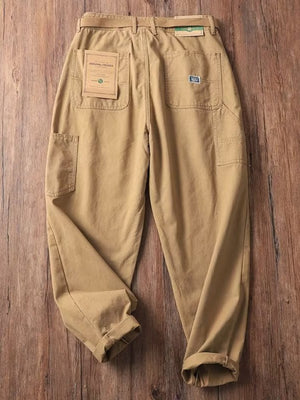 Men's tan loose fit cargo sweatpants with multiple pockets and a belt.