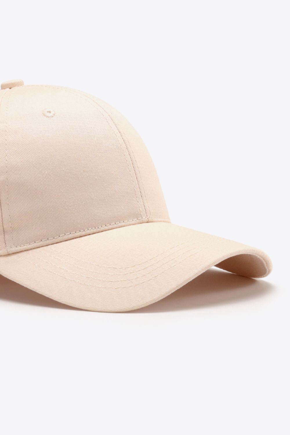 Cream cotton twill baseball cap with curved brim and stitched details.