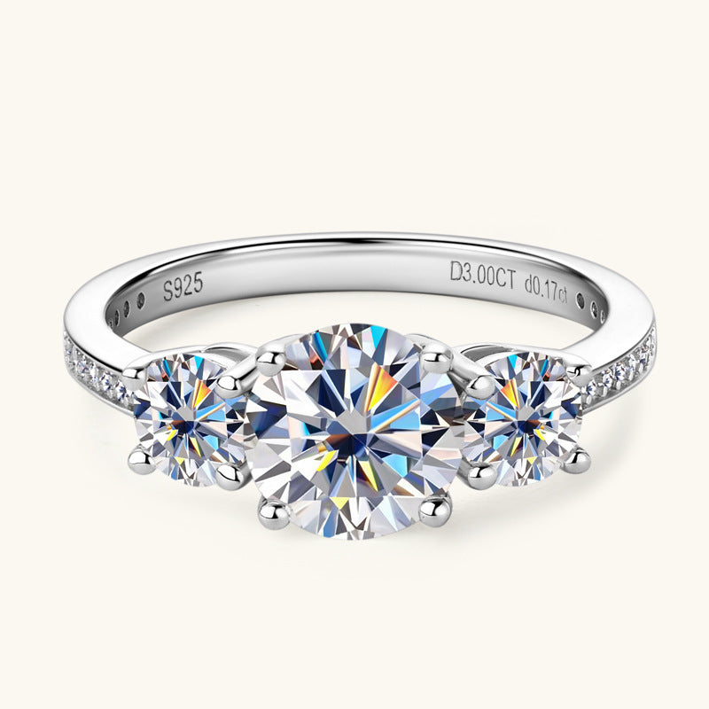 Silver band ring with three round moissanite stones and pavé accents.