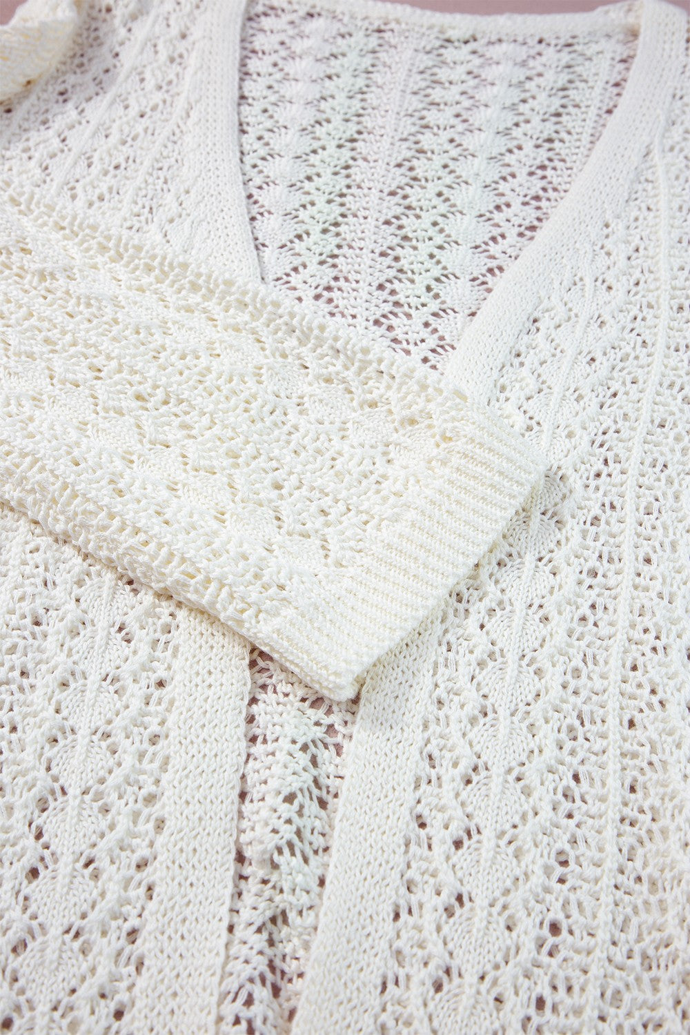 White open-knit crochet sleeve cardigan with intricate openwork pattern and ribbed cuffs.