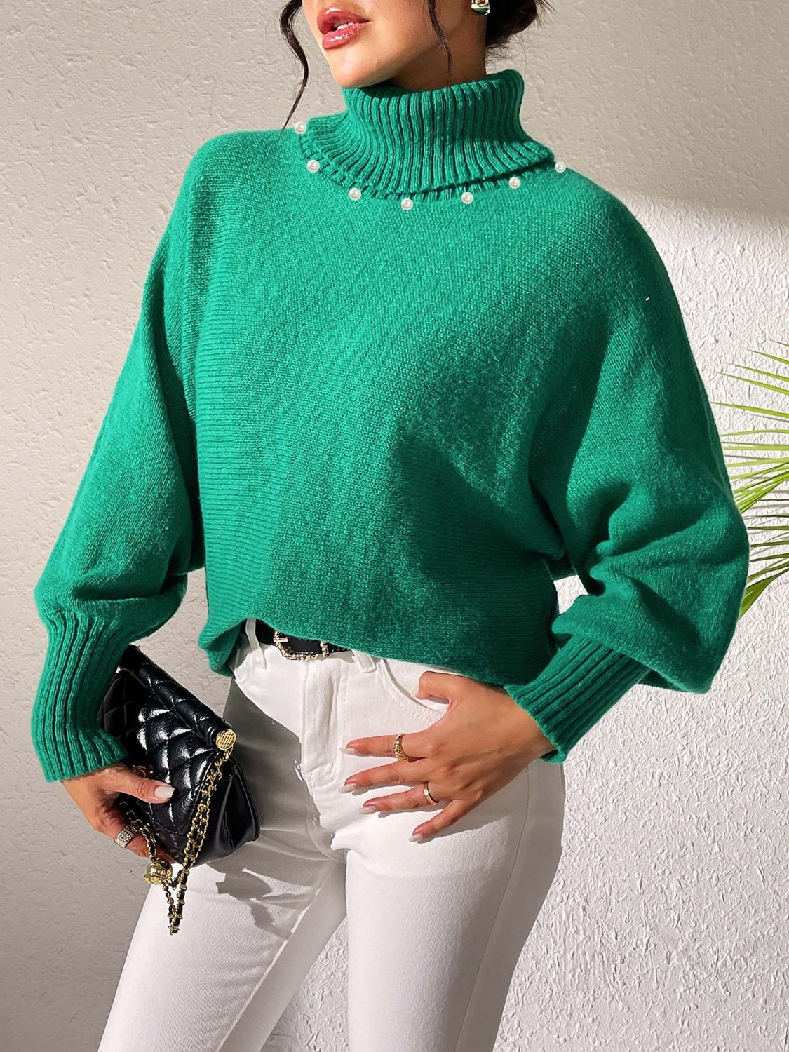 Green knit turtleneck sweater with dolman sleeves and pearl embellishments.