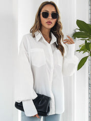 White oversized poplin blouse with blouson sleeves, button front, and two chest pockets.