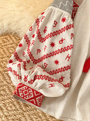 Embroidered folk shirt in cream with red embroidery on puff sleeves and cuffs.