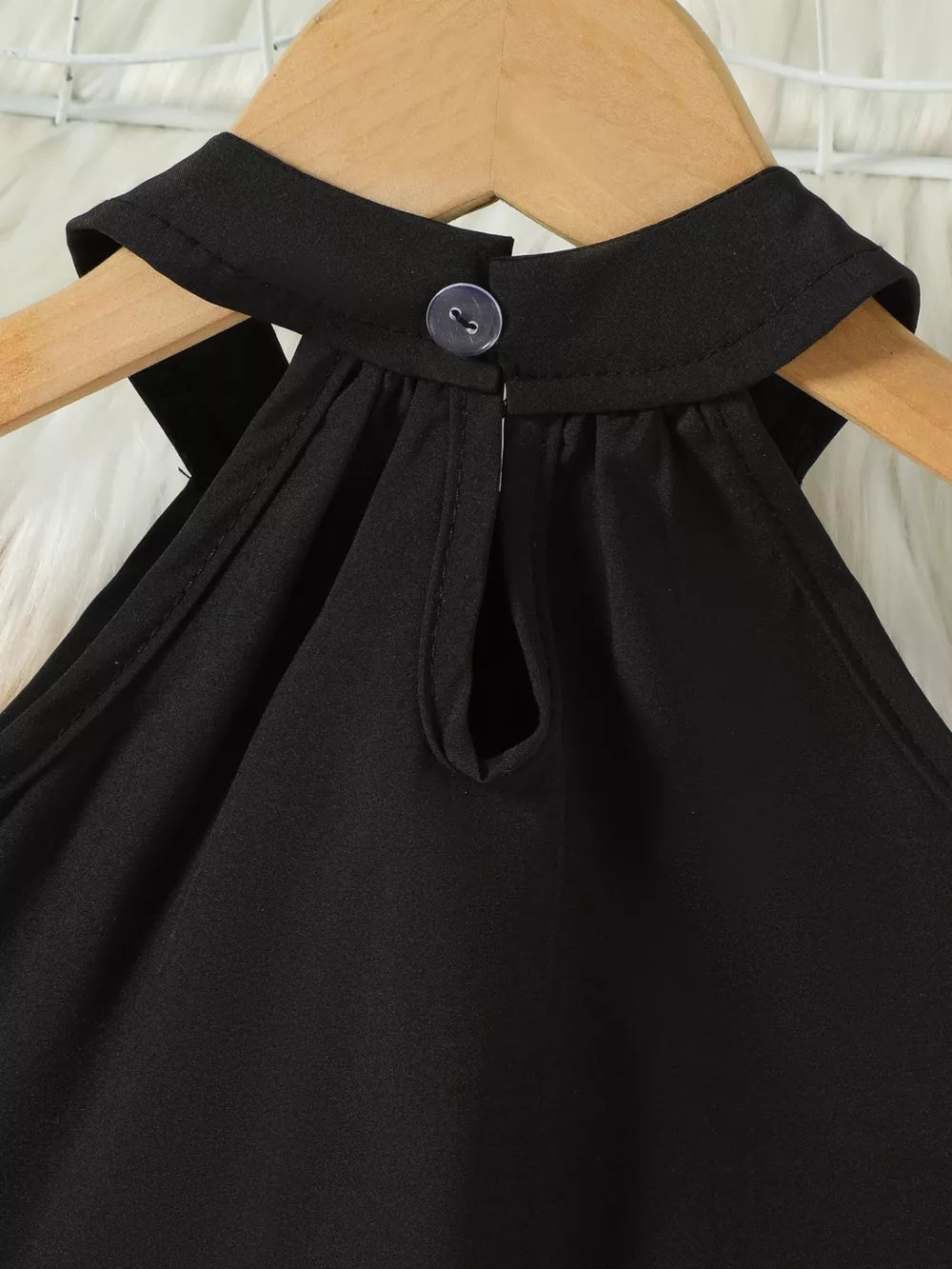 Black toddler top with halter neck, cutout detail, and button closure.