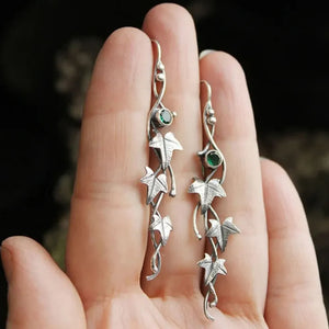 Silver drop earrings with green gemstones and ivy leaf charms.
