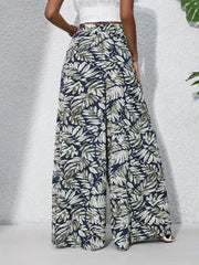 Palazzo trousers with tropical leaf print in navy, green, and white.