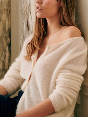 Cream cashmere buttoned cardigan with plunging neckline and long sleeves.
