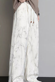 Men's white sweatpants with marbled pattern and drawstring waist.