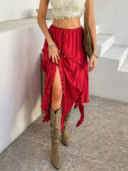 Scarlet midi skirt with cascading ruffles and a high slit, styled with a crop top and boots.