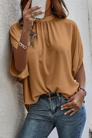 Camel blouse with drapey sleeves and mock neckline, styled with jeans.
