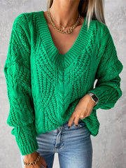 Green cable knit V-neck sweater with relaxed fit and textured pattern.