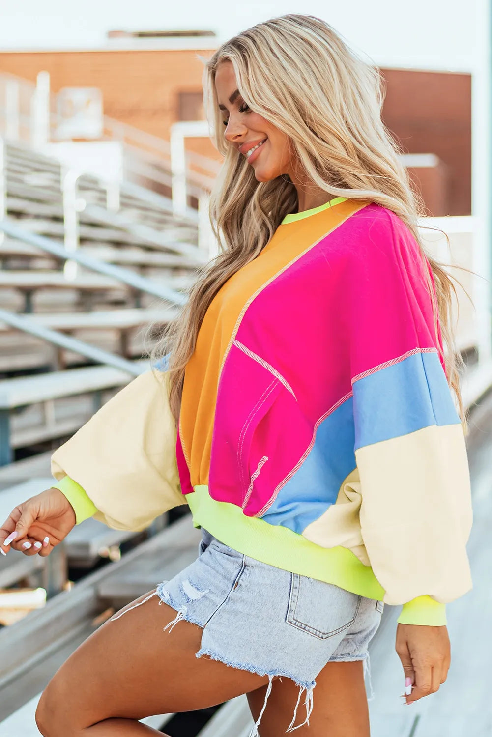 Colorblock paneled sweatshirt with neon trim in tangerine, pink, yellow, and blue.