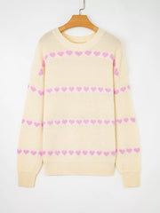 Cream knit sweater with pink heart pattern, crew neck, long sleeves.