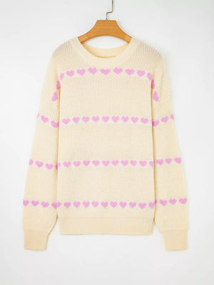 Cream knit sweater with pink heart pattern, crew neck, long sleeves.