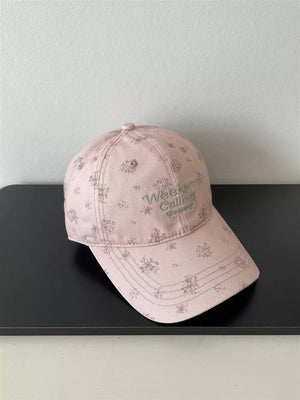 Pink floral embroidered baseball cap with "Weekend Calling" text.