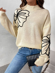 Pastel yellow acrylic knit sweater with embroidered black floral motifs on the chest and sleeves.