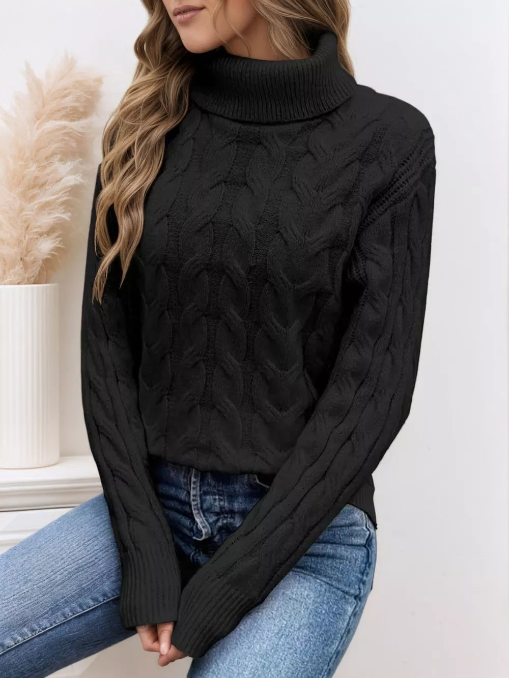 Black cable-knit turtleneck sweater with long sleeves and ribbed cuffs.