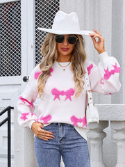 White knit pullover sweater with pink bow motif and balloon sleeves.