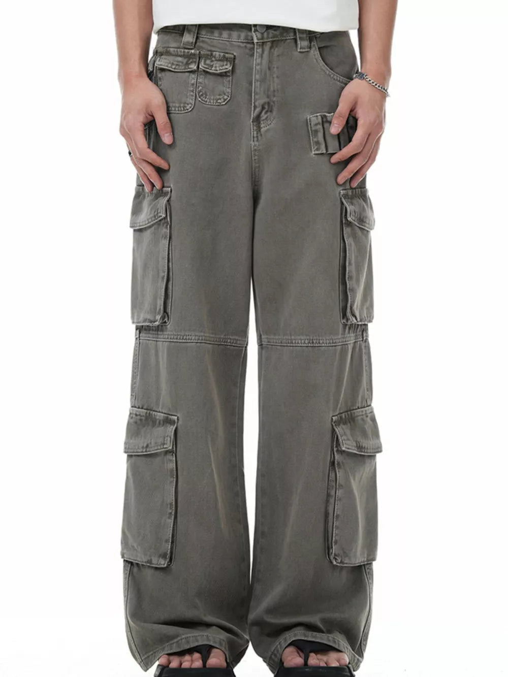 Men's grey distressed cargo pants with multiple utility pockets and a relaxed fit.