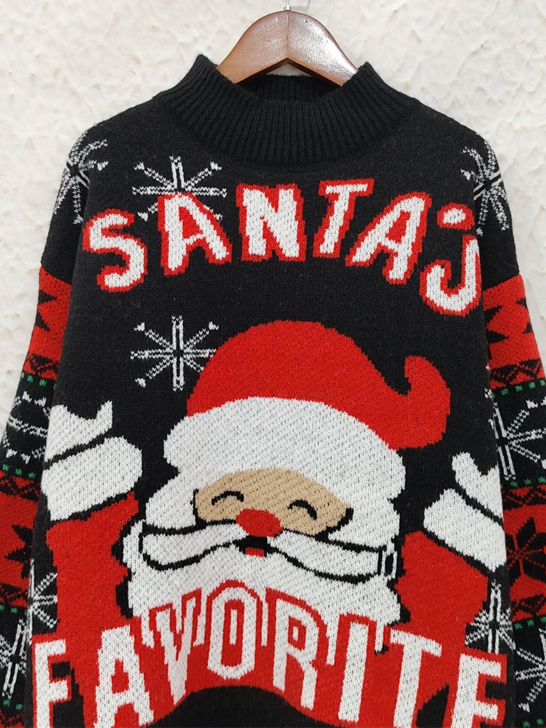 Black acrylic knit sweater with Santa graphic and "Santa's Favorite" text.