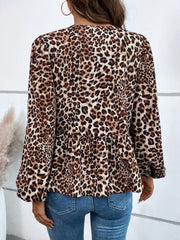 Leopard print peplum blouse with long sleeves and a ruffled hem.