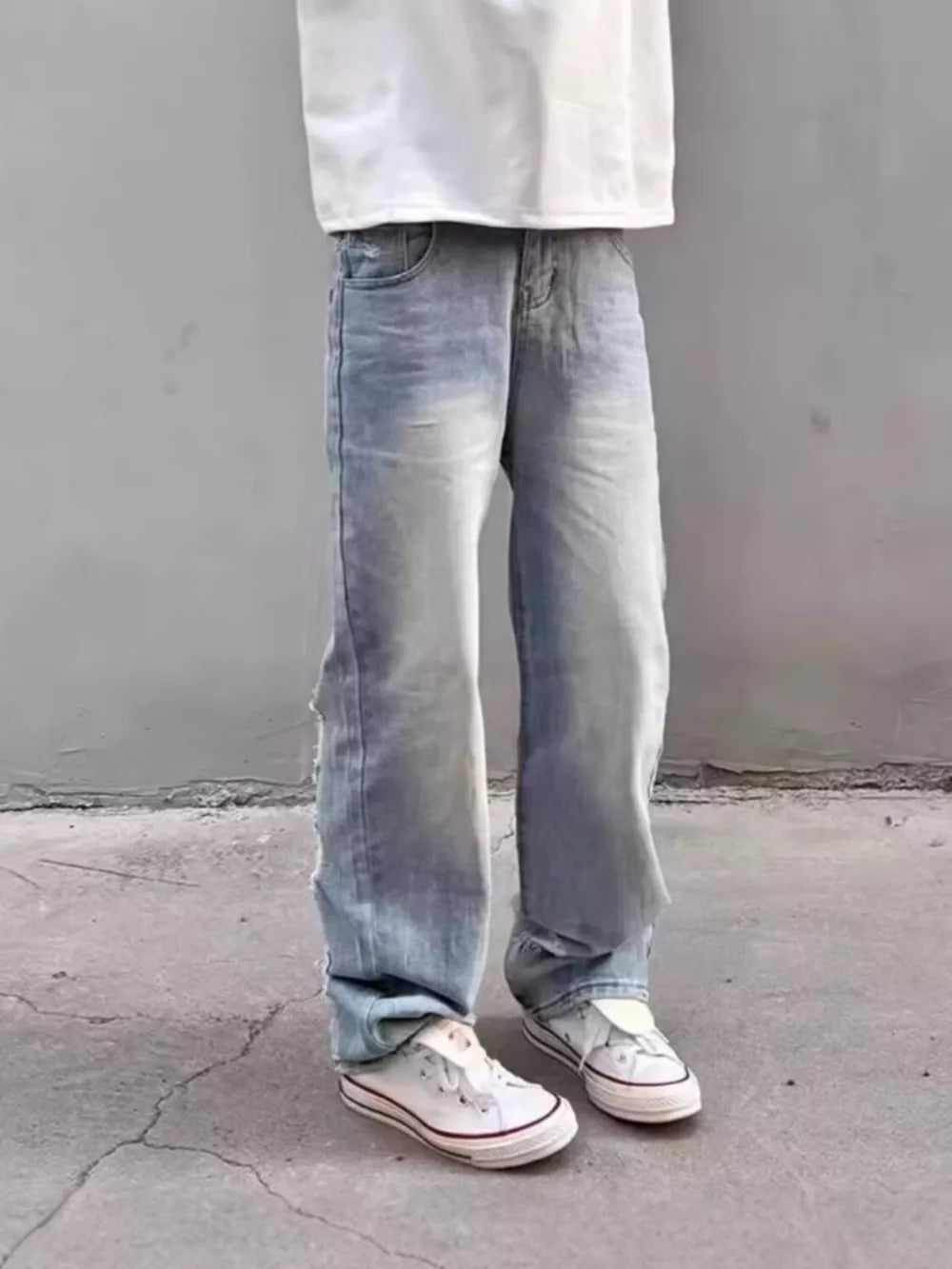 Light wash distressed wide leg jeans with a relaxed fit.