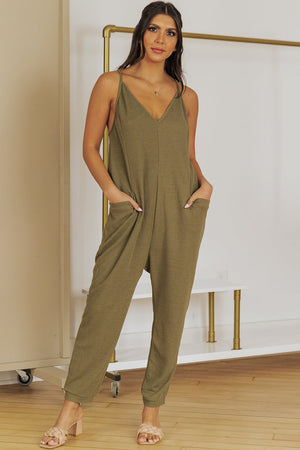 Relaxed-fit olive green jersey jumpsuit with V-neck, spaghetti straps, and slouch pockets.