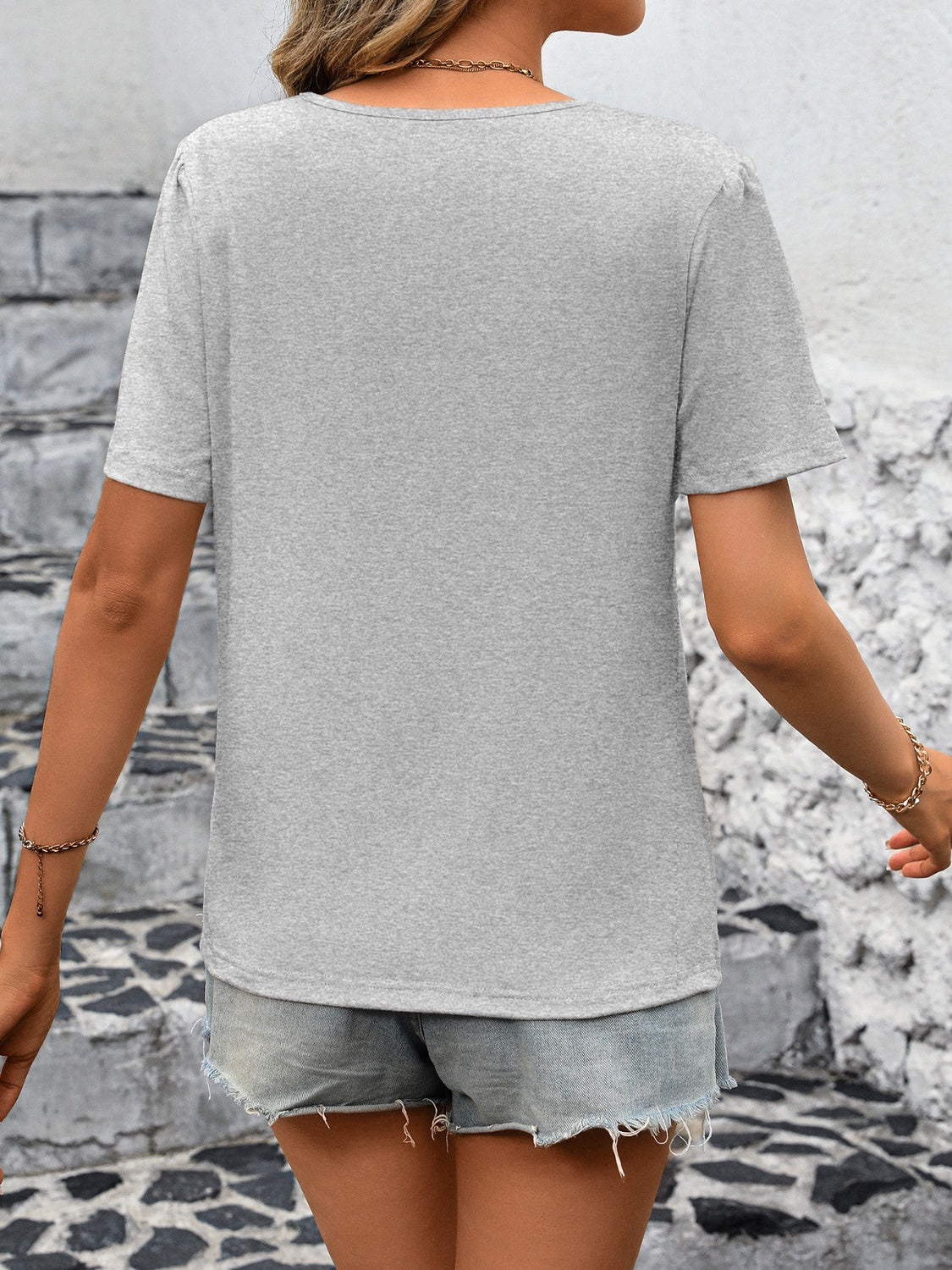 Light gray jersey top with pleated shoulder detail and short sleeves.