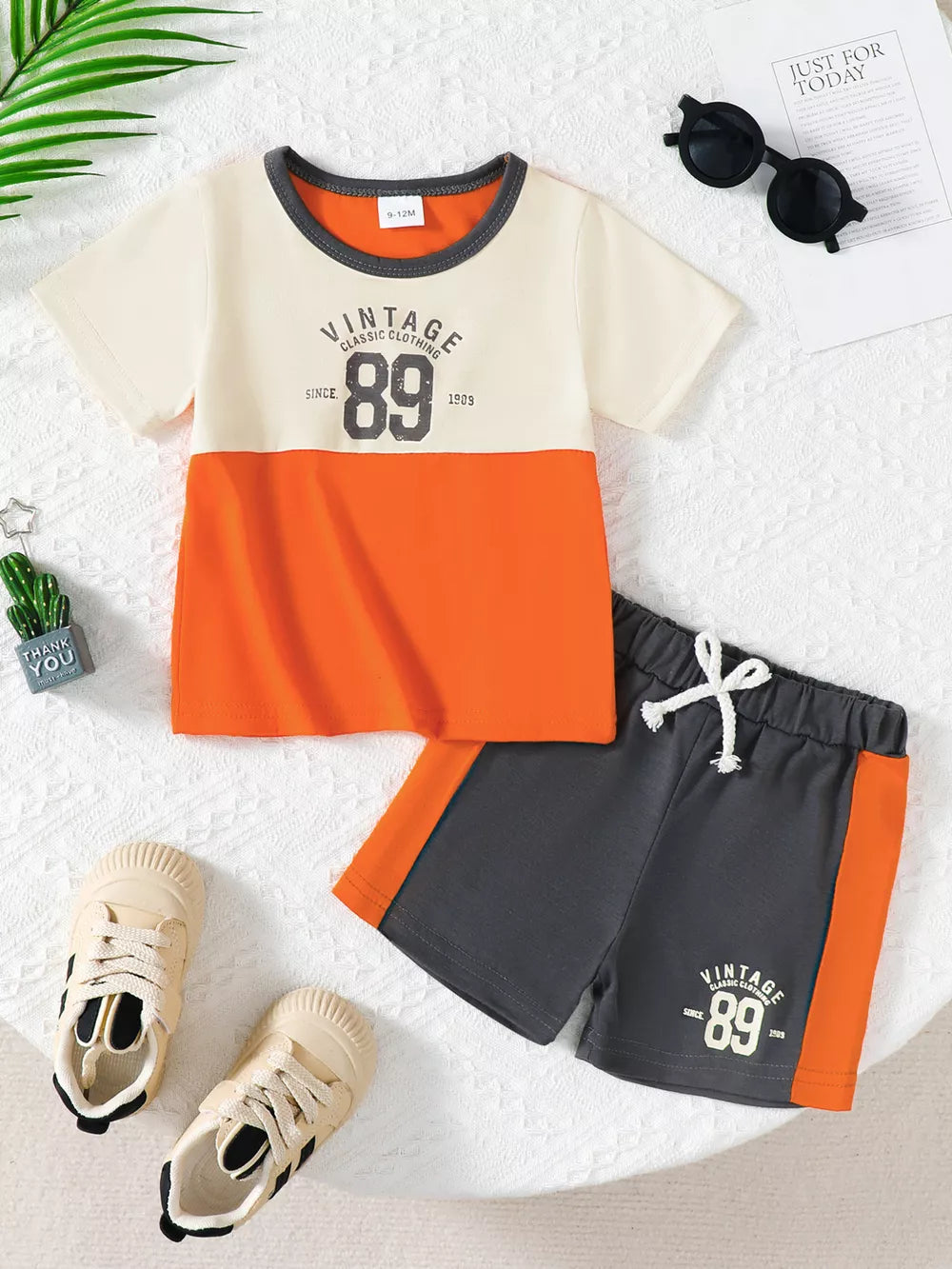Color block baby outfit with graphic tee and shorts, featuring orange and cream colors.