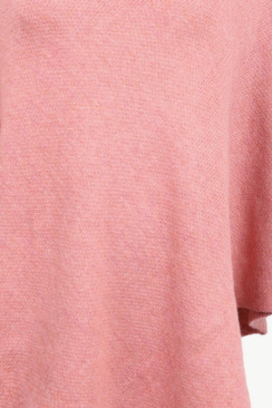 Button-detail turtleneck knit poncho in coral acrylic with a textured knit.