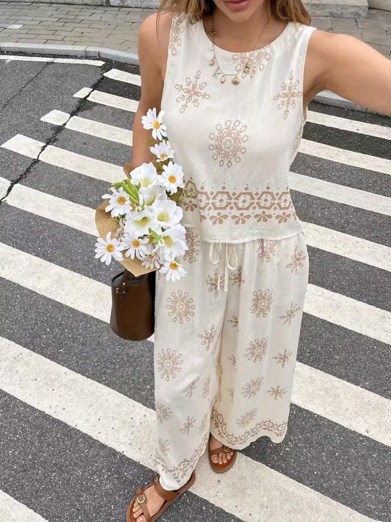 White two-piece set with medallion print, sleeveless top and drawstring pants.