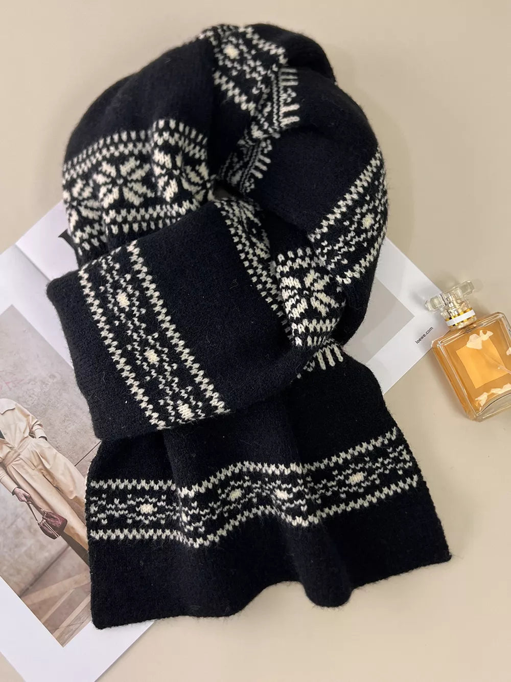 Black wool blend scarf with white snowflake pattern and fringe detail