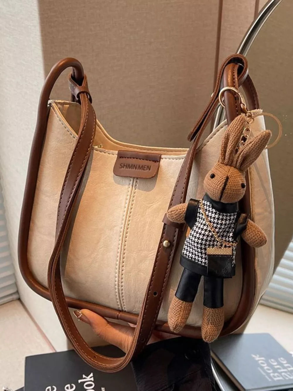 Off-white pu leather shoulder bag with brown piping and a bunny charm