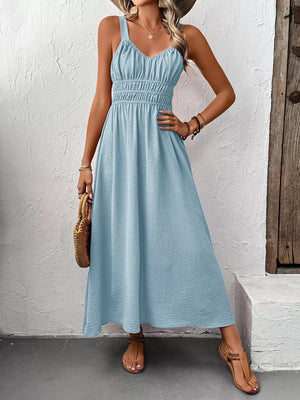 Light blue V-neck smocked midi dress with spaghetti straps and a flowy skirt.