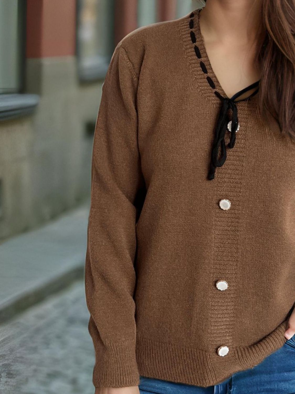 Brown knit cardigan with black ribbon trim and pearl buttons.