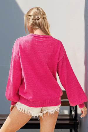 Hot pink knit sweater with balloon sleeves and sequin nutcracker embellishment.